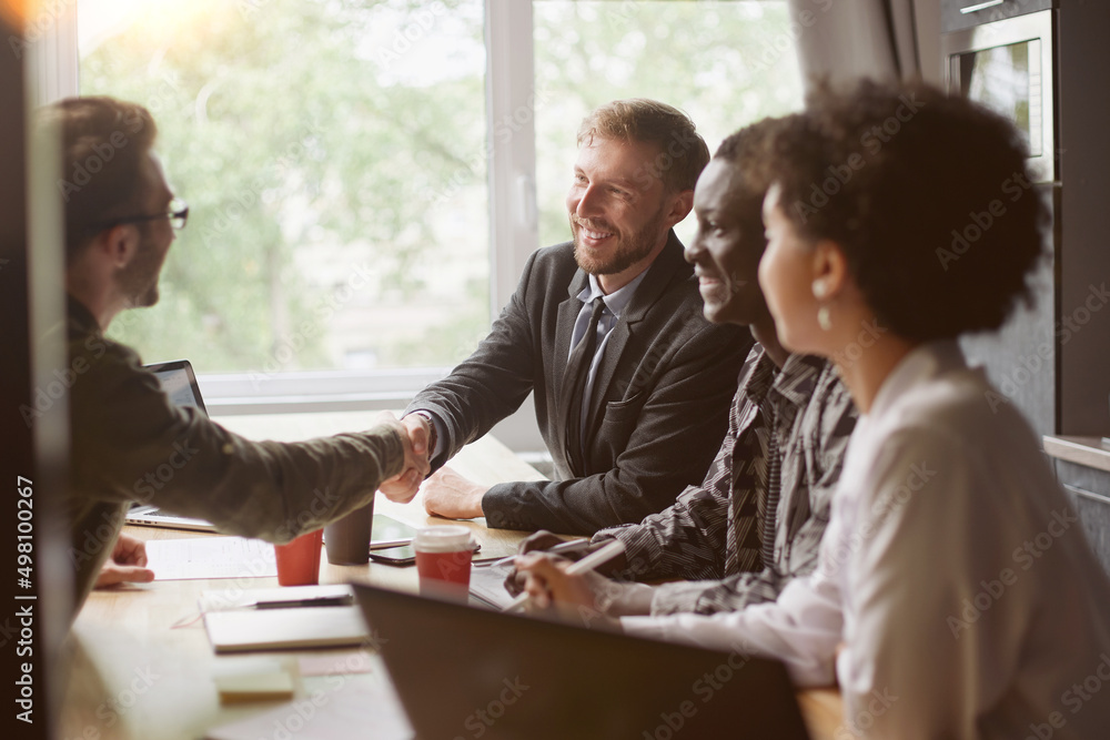 business people greet each other at the table in the coworking c business people greet each other at the table in the coworking c
