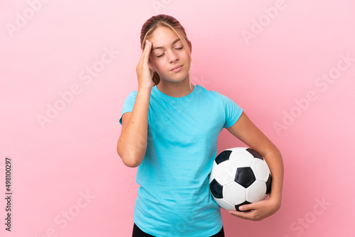 Little football player girl isolated on pink background with headache