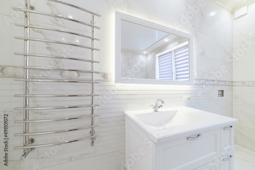 white bathroom interior with backlit mirror and tiles