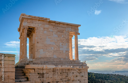 The Temple of Athena Nike, on the Acropolis of Athens, Greece, named after the Greek goddess Athena. Philopappos Hill, Piraeus and the Saronic gulf are in the background.