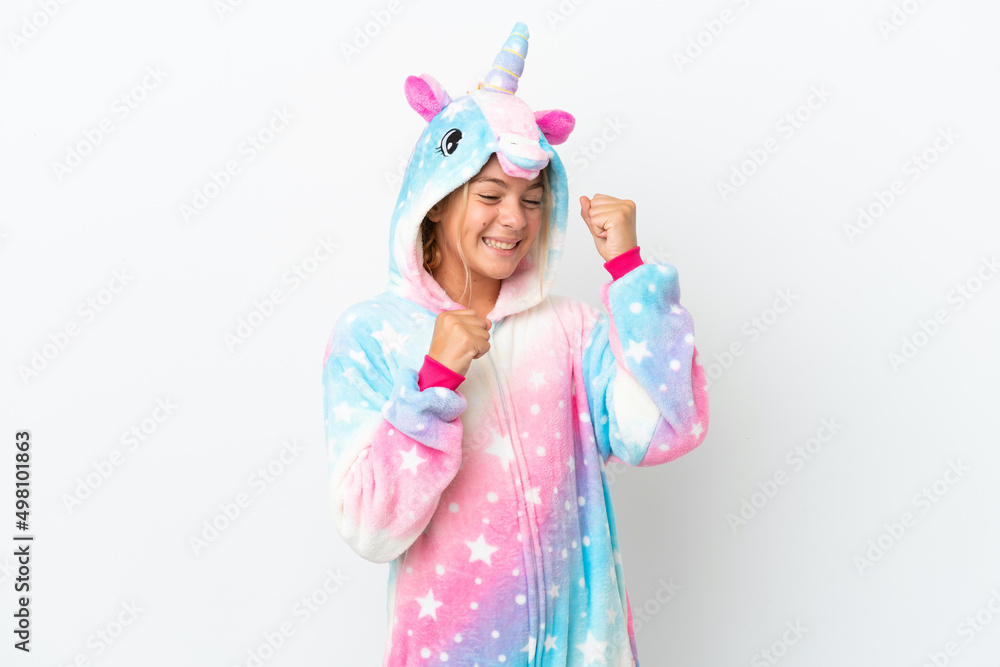 Little girl with unicorn pajamas isolated on white background celebrating a victory