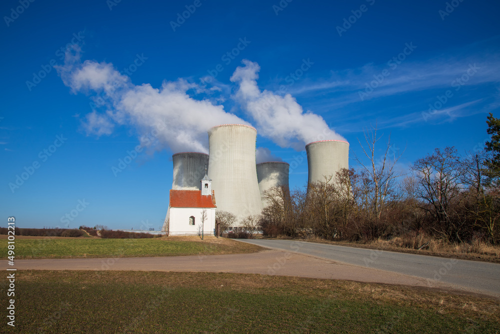 Dukovany Nuclear Power Plant in the Czech Republic, Europe. Smoke cooling towers. There are clouds in the sky. In the background the nature of the Highlands. Dukovany Nuclear Power Plant in the Czech Republic, Europe. Smoke cooling towers. There are clouds in the sky. In the background the nature of the Highlands.