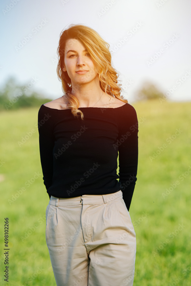 Sunlit portrait of a beautiful woman in her thirties over a grass field Sunlit portrait of a beautiful woman in her thirties over a grass field