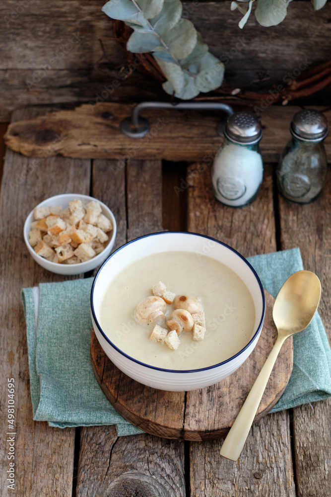 Cream soup with mushrooms and crackers.Wooden background, side view Cream soup with mushrooms and crackers.Wooden background, side view