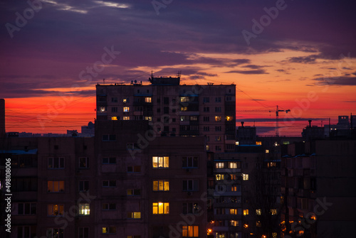 Residential apartment buildings against the background of the evening sky. Soviet panel dilapidated multistorey buildings. Dysfunctional residential area in the evening. Light in the windows of buildi