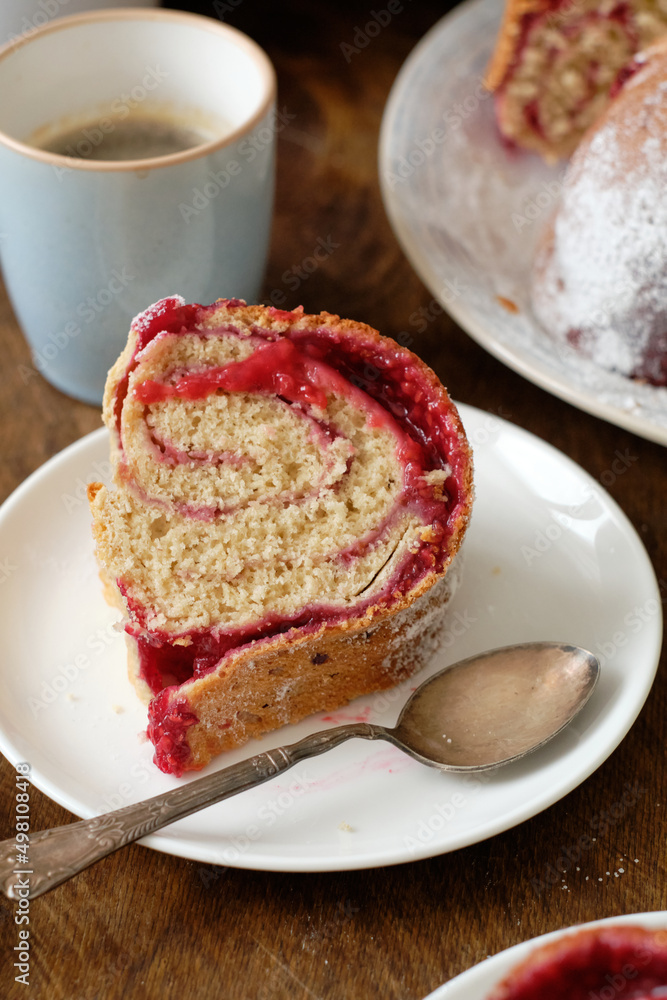 Raspberry roll wreath. Brioche. Side view, wooden background, coffee, powdered sugar, yeast buns. Raspberry roll wreath. Brioche. Side view, wooden background, coffee, powdered sugar, yeast buns.