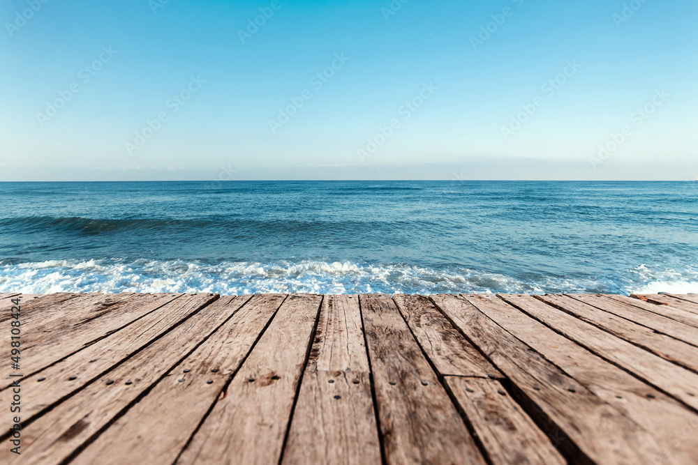 Fototapeta premium Old boards, floor against the background of the blue sea and sky. The concept of vacation, travel, vacation, wallpaper.