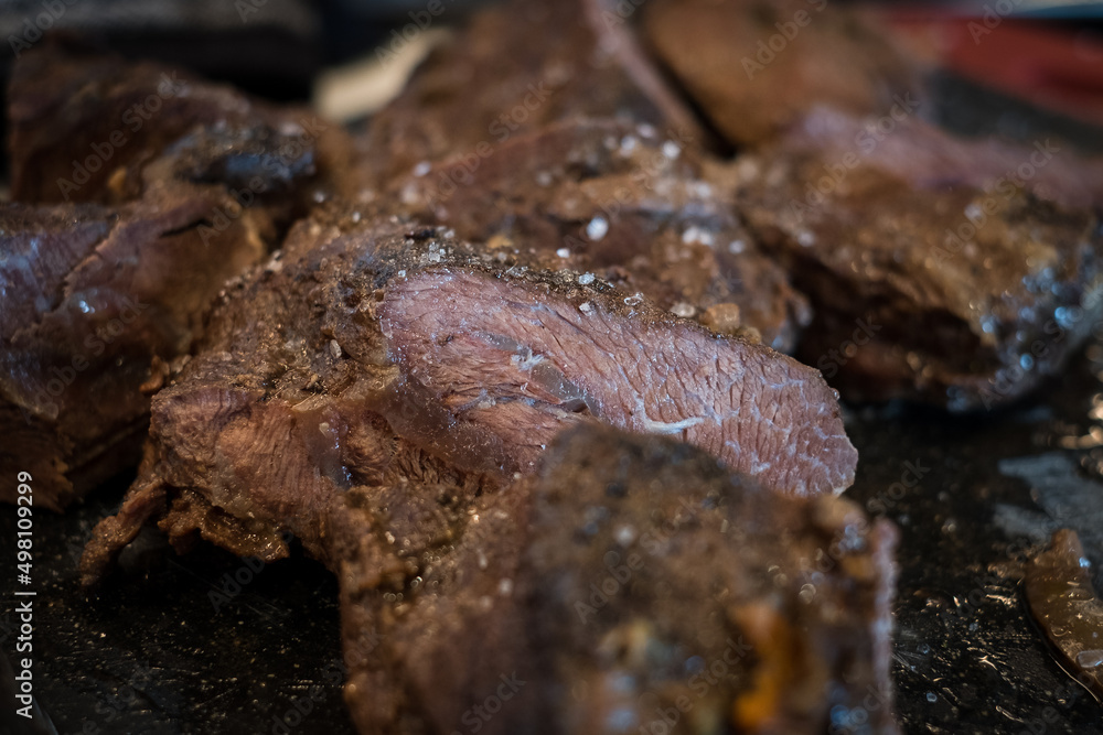 Braised beef cheeks cooked in red wine sauce on cutting board. Slow cooked meat stew. Braised beef cheeks cooked in red wine sauce on cutting board. Slow cooked meat stew.