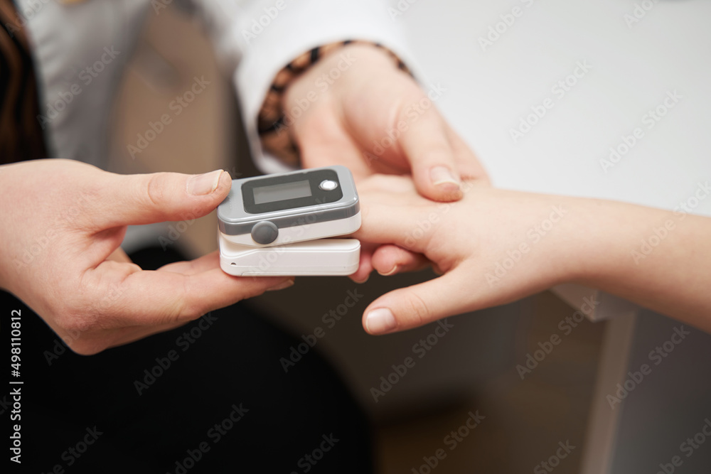 Doctor putting pulse oximeter sensor on child finger Doctor putting pulse oximeter sensor on child finger