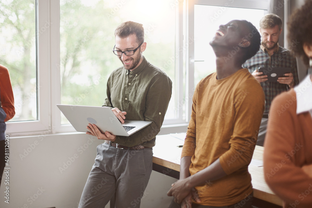 cheerful young employees standing near a table in a coworking ce cheerful young employees standing near a table in a coworking ce