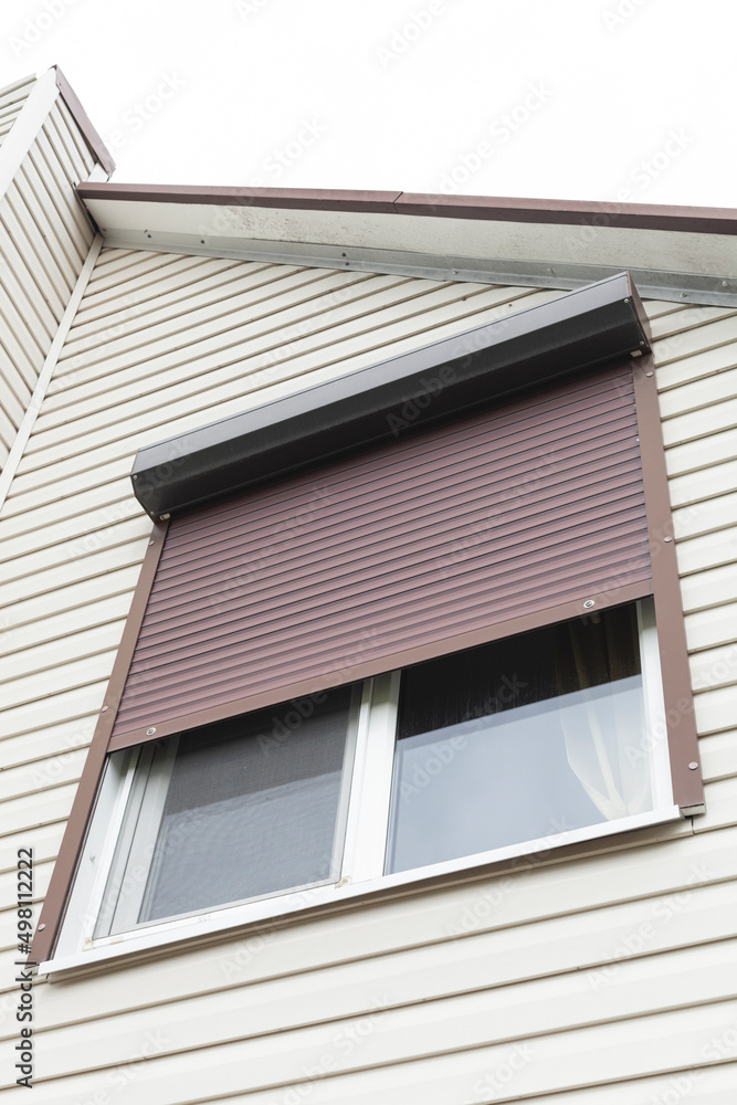 close-up photo of a window with roll shutters on the façade of a private house close-up photo of a window with roll shutters on the façade of a private house