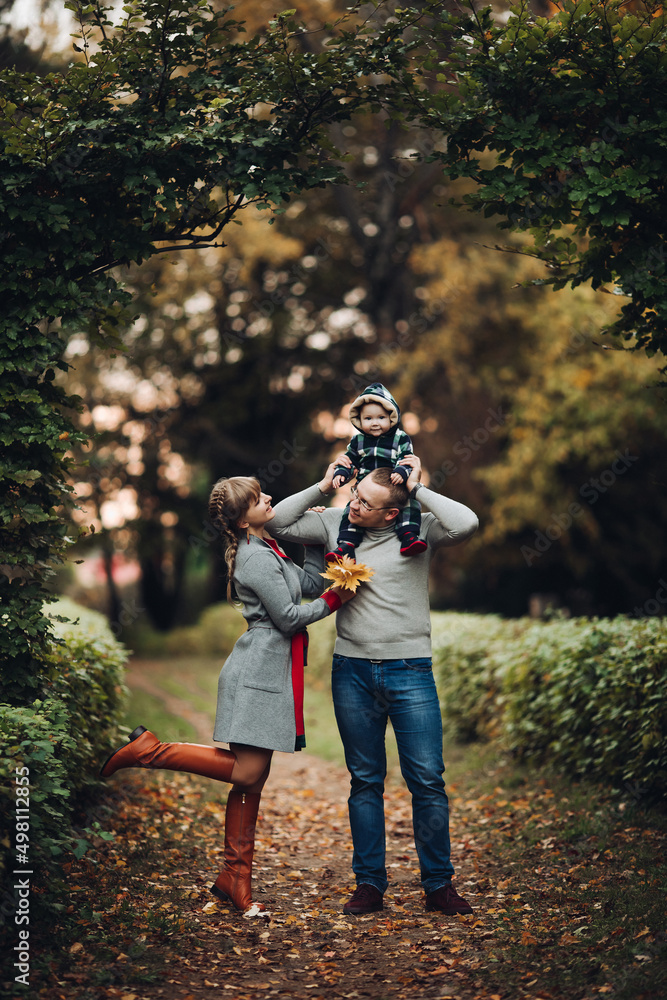 Fototapeta premium Beautiful and happy family with little child in park.