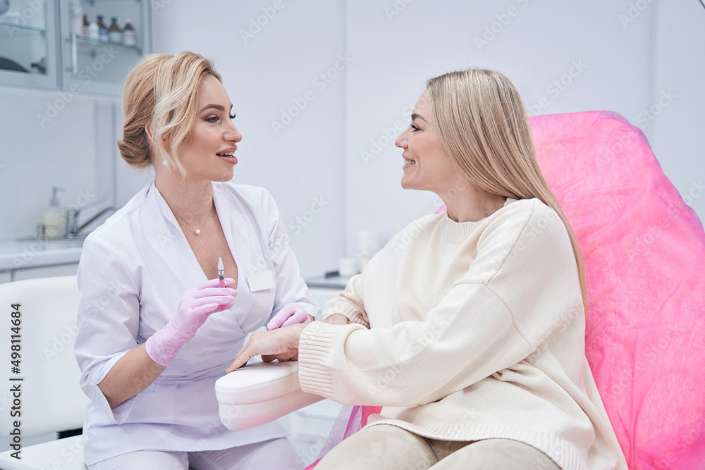 Obraz premium Dermatologist conversing with her patient before mesotherapy procedure