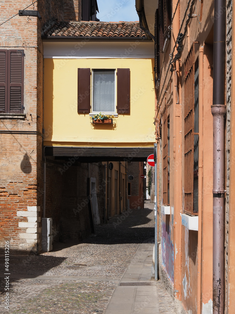 Fototapeta premium Ferrara, Italy. Downtown, medieval cobbled street with archway.