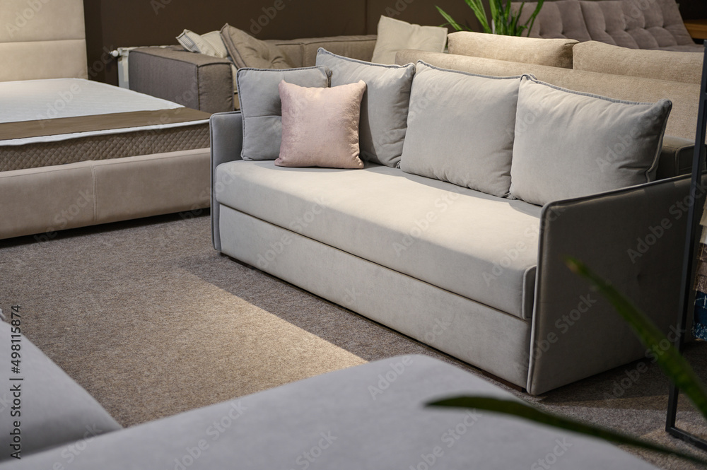 Exposition of upholstered modern comfortable light gray settee with