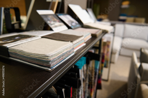 Samples of fabrics of different quality, texture and category for furniture upholstery in a modern spacious exhibition hall, showroom of a furniture store. Upholstery fabric samples © Taras Grebinets