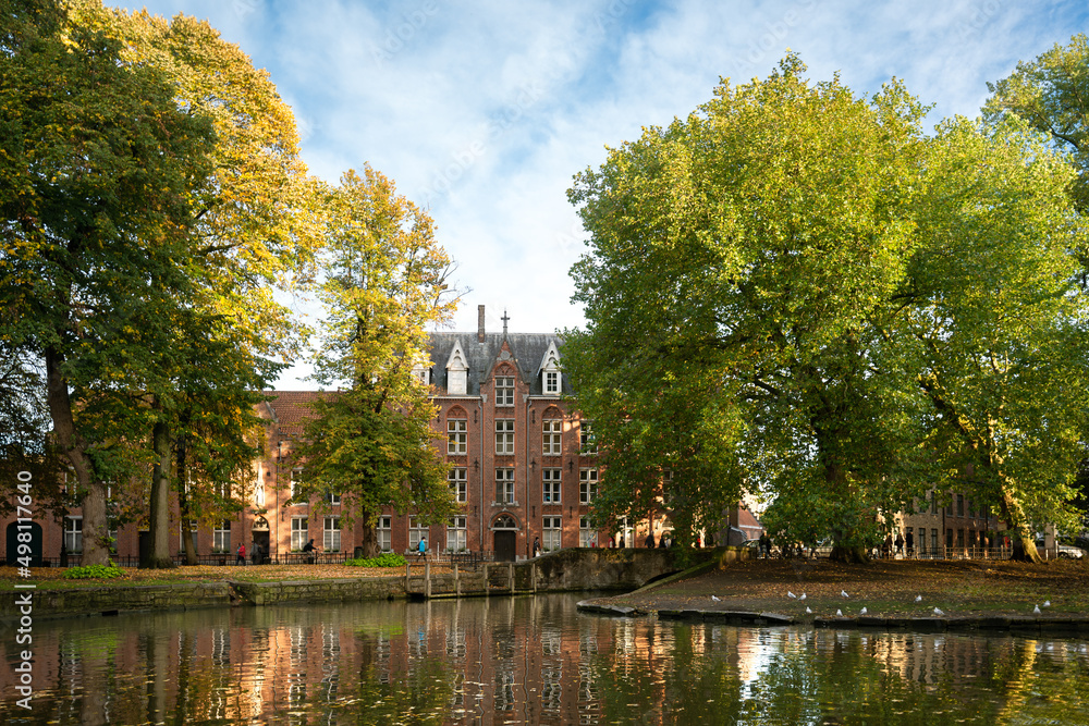 View of canal and historic buildings in Bruges. Wijngaardplein park, Former monastery of the sisters of Saint Vicenzo a Paolo (Voormalig klooster van de zusters van de Heilige Vicenzo a Paolo)