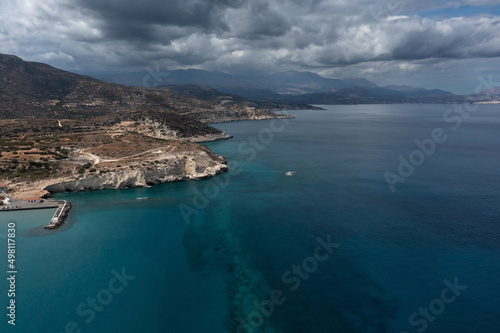 Mediterranean coastline with mountains, white rocks and clear sea under dramatic sky, Crete, Greece