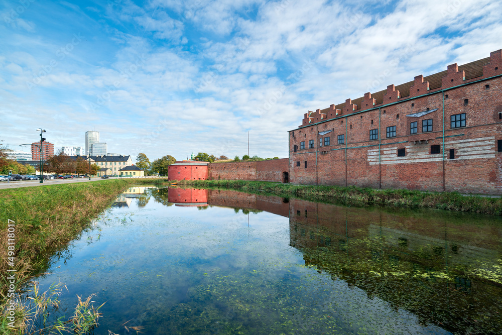 Historic Malmöhus Castle (Slott) in Malmö, gun tower, protective moat, reflection in the water. Malmo city, Skane, Sweden.