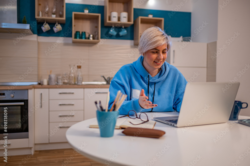 Woman on a video call with colleagues while using laptop and working from home Woman on a video call with colleagues while using laptop and working from home