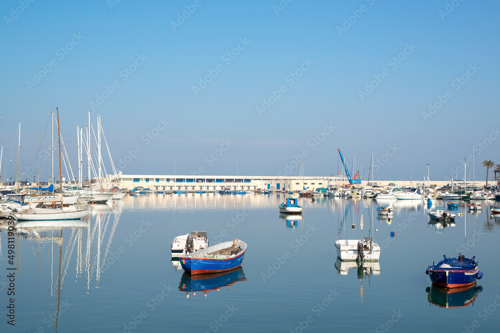 Sea Port whit Luxury yachts. Sailing boats in a quiet harbor. Clear blue sky and calm sea. Bari, Italy.