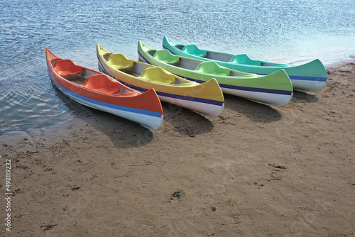 Empty colorful canoes on the shore.