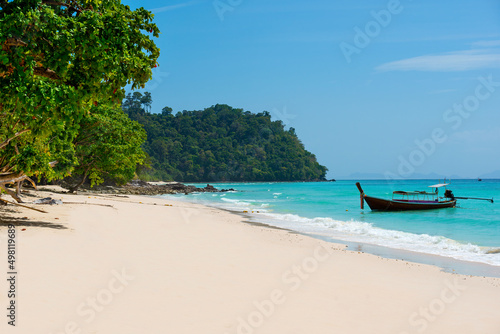 Beautiful empty exotic tropical beach with white clean sand and crystal clear sea water. Island landscape with a view to Longtail boat. Koh Rok Island, Thailand.