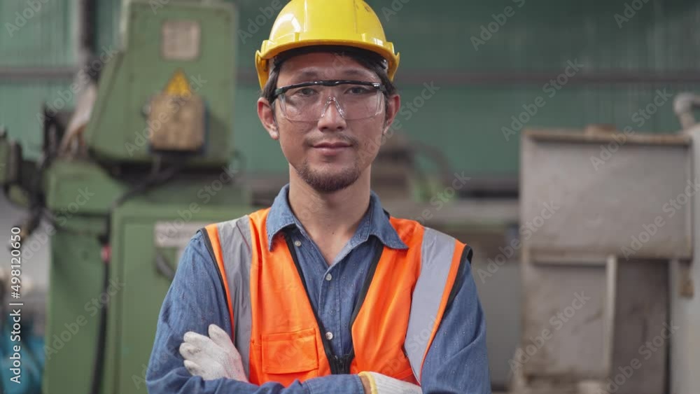 Zoom in portrait Asian male engineer of technician worker in safety clothing smiling to camera. Machine inspector or mechanic standing in a factory. people working for industrial construction site Zoom in portrait Asian male engineer of technician worker in safety clothing smiling to camera. Machine inspector or mechanic standing in a factory. people working for industrial construction site
