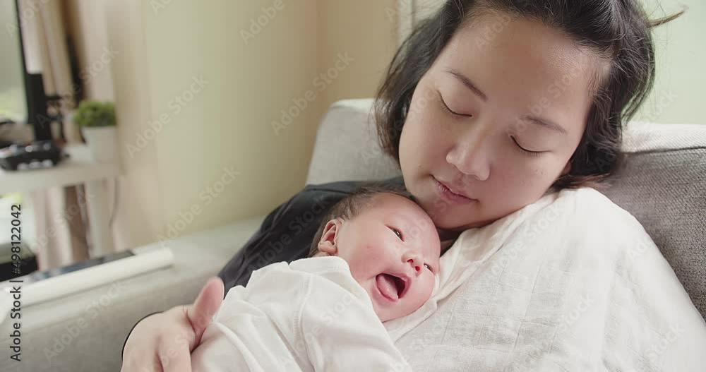 Happy family Asian mother holding caressing hugging newborn baby infant