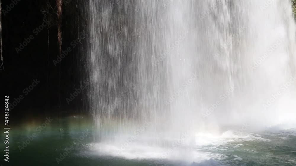 Water falling from a waterfall and a rainbow over the water