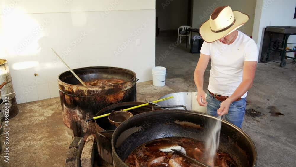 Muchacho señor trabajador preparando haciendo y cocinando rico y delicioso platillo típico carnitas comida carne de cerdo puerco en manteca aceite