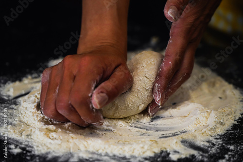 flour falling on a dark table. preparing the homemade bread making process. photo inside.