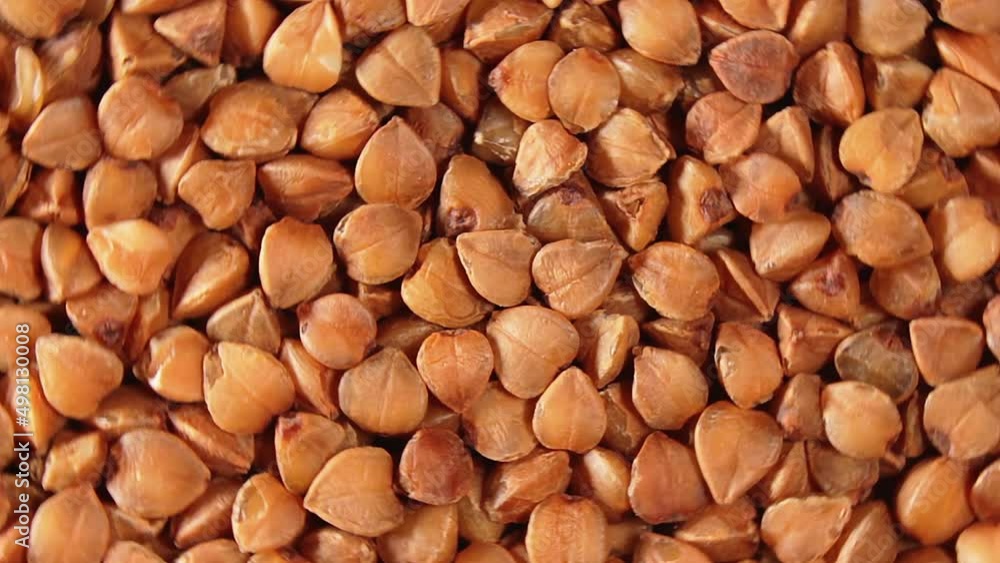 Dry Uncooked Brown Buckwheat Groats, Rotating Background - Top View, Close-Up, Macro. Raw Large Buckwheat Grains. Russian, Ukrainian and Belarusian Culture. Rotation Left Dry Uncooked Brown Buckwheat Groats, Rotating Background - Top View, Close-Up, Macro. Raw Large Buckwheat Grains. Russian, Ukrainian and Belarusian Culture. Rotation Left