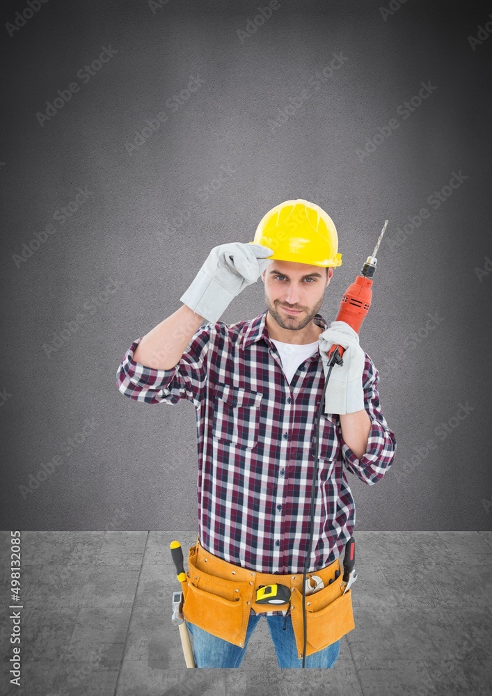 Portrait of caucasian male worker holding a drill machine against copy space on grey background Portrait of caucasian male worker holding a drill machine against copy space on grey background