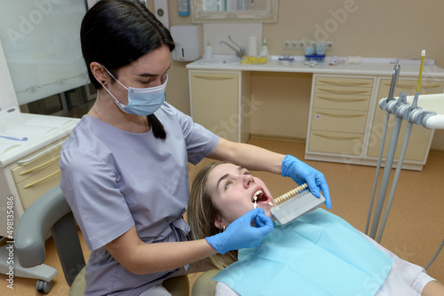 Selection of the correct tooth color for professional cosmetic bleaching at the dentist.