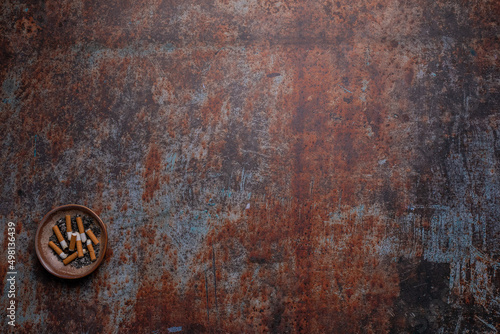 Ashtray on lower left edge on rusty background - World no Tobacco Day