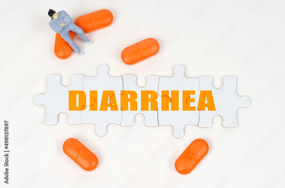 On the white surface of the tablet, a miniature human figure and puzzles with the inscription - DIARRHEA On the white surface of the tablet, a miniature human figure and puzzles with the inscription - DIARRHEA