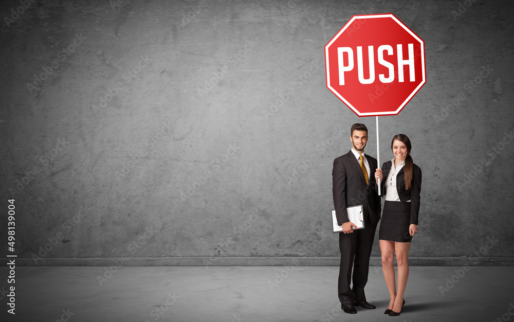 Young business person holding road sign Young business person holding road sign