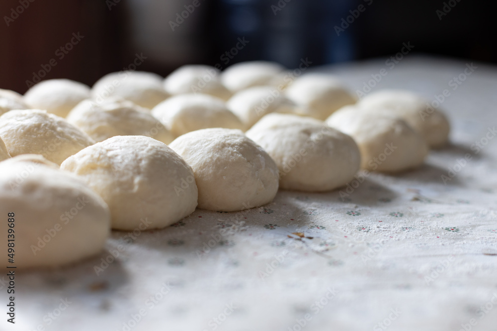 Balls from the dough for pies on the kitchen table. Baking at home. Selective focus.