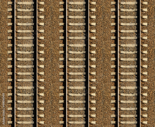 Seamless railroad Pattern, backdrop with space for text. Top view. Shiny iron rails and concrete sleepers, coupled with powerful bolts on stony ground, fortified rubble overgrown with weeds green photo