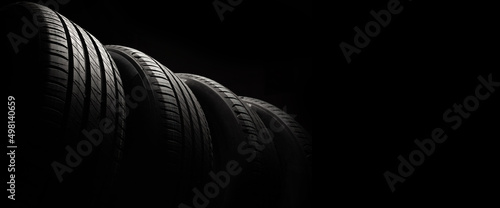 New car tires. Group of road wheels on dark background. Summer Tires with asymmetric tread design. Driving car concept. photo