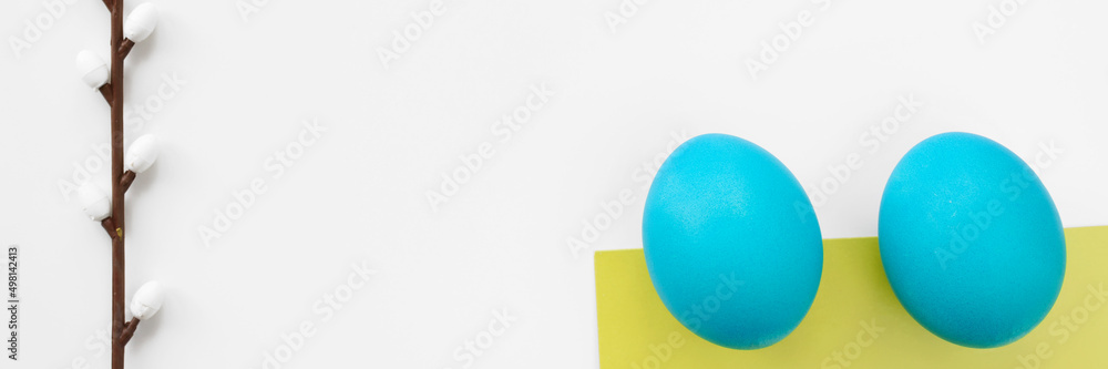 Panoramic photo. Top view of blue easter eggs lying on white table and twig with catkins. Copy space. Easter concept. Panoramic photo. Top view of blue easter eggs lying on white table and twig with catkins. Copy space. Easter concept.