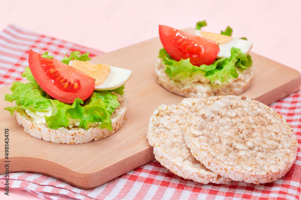 Rice Cake Sandwiches with Tomato, Lettuce and Egg on Wooden Cutting Board. Easy Breakfast. Diet Food. Quick and Healthy Sandwiches. Crispbread with Tasty Filling. Healthy Dietary Snack