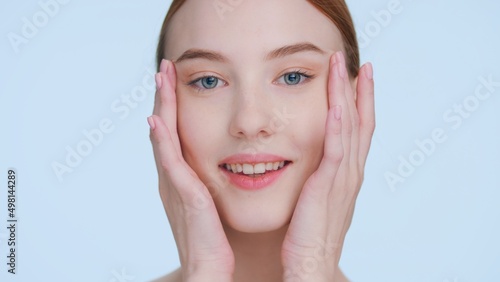 Young woman touches her face demonstrating skin elasticity