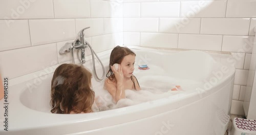 Children bathe in the bathroom with foam and play with a turtle. Go to a dream with fantasy.