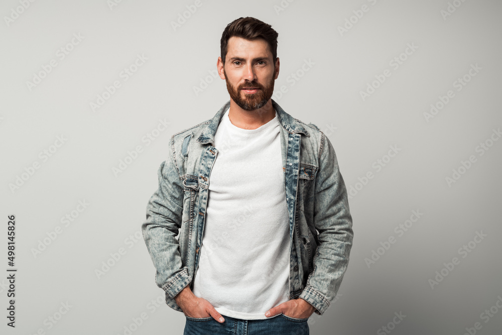 Bearded handsome man in casual style looking at the camera and smiling while posing Bearded handsome man in casual style looking at the camera and smiling while posing