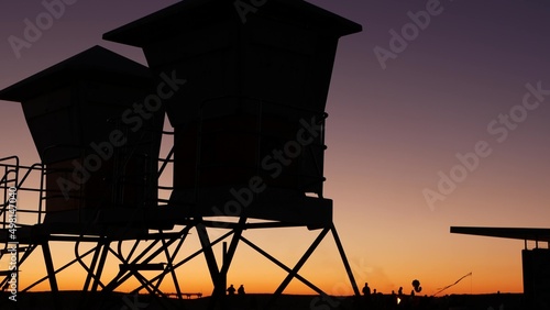 Lifeguard stand, hut or house on ocean beach after sunset, California coast, USA. Life guard tower or station silhouette in twilight dusk. Contrast beachfront watchtower for surfing safety on shore.