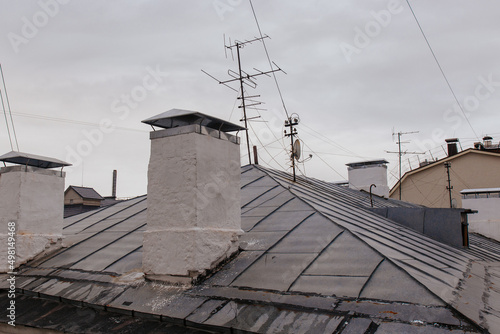 Satellite antenna and old roof antenna on a red roof