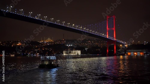 Istanbul Bosphorus Bridge at night. 15 July Martyrs Bridge. Istanbul Turkey. Cinematic panorama. Smooth flowing, heavy traffic during rush hour on Bosporus Bridge.  The ciragan palace kempinski. photo