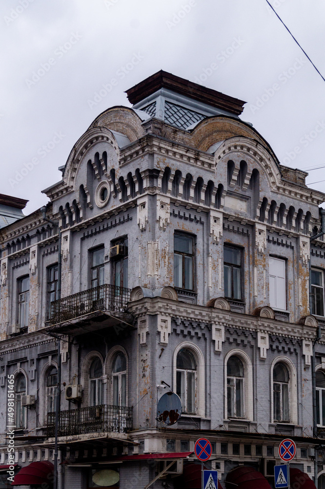 Facade with balconies of the old house in city in cloudy day. Old building with balcony